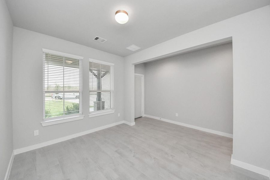 Experience the perfect blend of sophistication and warmth in this home office, boasting elegant wood-look tile flooring and flooded with natural light from expansive windows. Sample photo of completed home with similar floor plan. Actual colors and selections may vary. Experience the perfect blend of sophistication and warmth in this home office, boasting elegant wood-look tile flooring and flooded with natural light from expansive windows. Sample photo of completed home with similar floor plan. Actual colors and selections may vary.