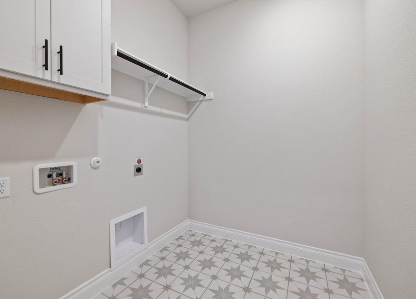 Clothes washing area featuring cabinet space, electric dryer hookup, baseboards, gas dryer hookup, and light floors Clothes washing area featuring cabinet space, electric dryer hookup, baseboards, gas dryer hookup, and light floors