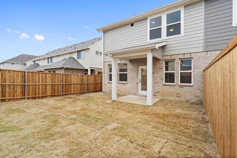 Back of house featuring a yard and a patio area