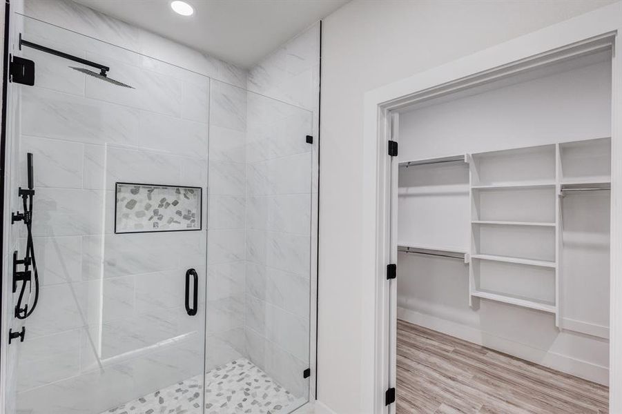 Bathroom featuring hardwood / wood-style floors and a shower with shower door