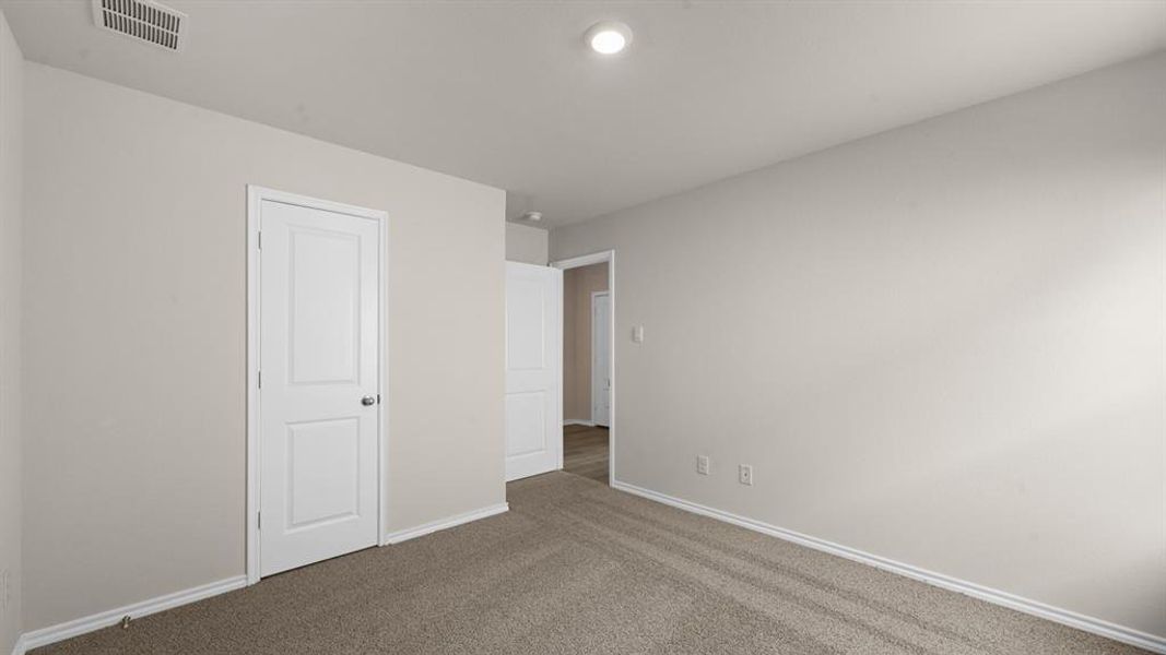 Neutral-toned wall paint with white baseboards, plush carpet flooring, recessed ceiling lighting, and a paneled interior door with chrome hardware Neutral-toned wall paint with white baseboards, plush carpet flooring, recessed ceiling lighting, and a paneled interior door with chrome hardware