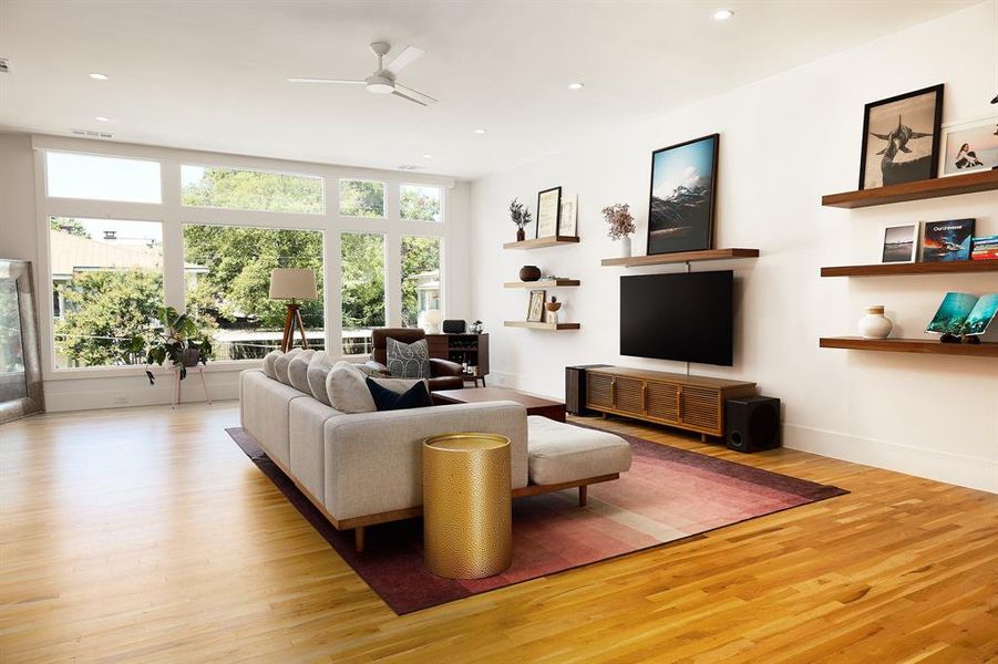 Living room featuring bright natural light, fan, wood finished floors, and recessed lighting
