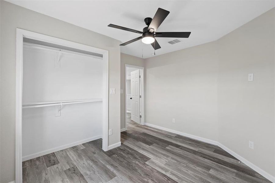 Unfurnished bedroom featuring light wood-type flooring, a closet, and a ceiling fan Unfurnished bedroom featuring light wood-type flooring, a closet, and a ceiling fan