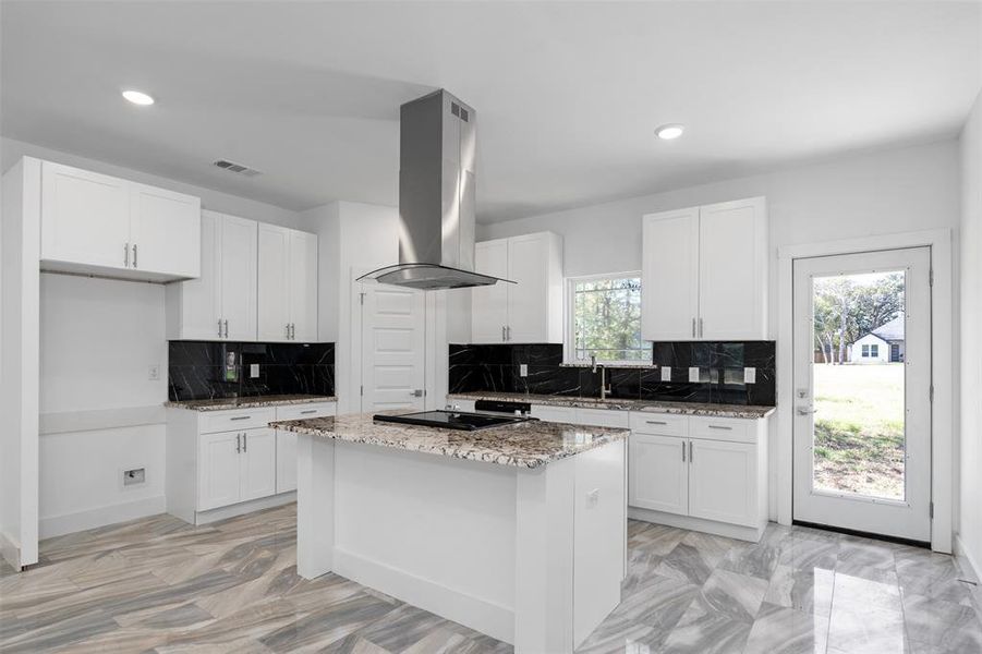 Kitchen with white cabinetry, backsplash, island range hood, and a center island