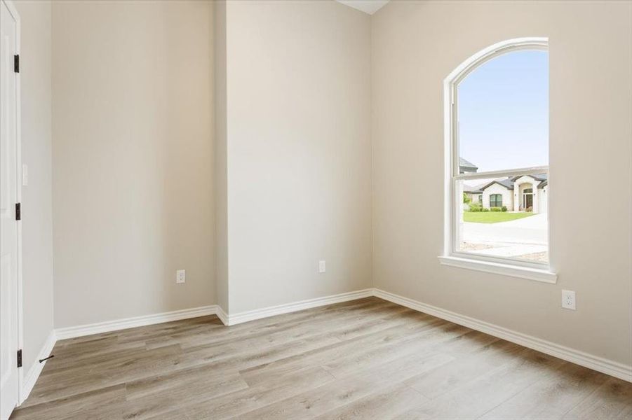 Unfurnished room with light wood-style floors and baseboards Unfurnished room with light wood-style floors and baseboards