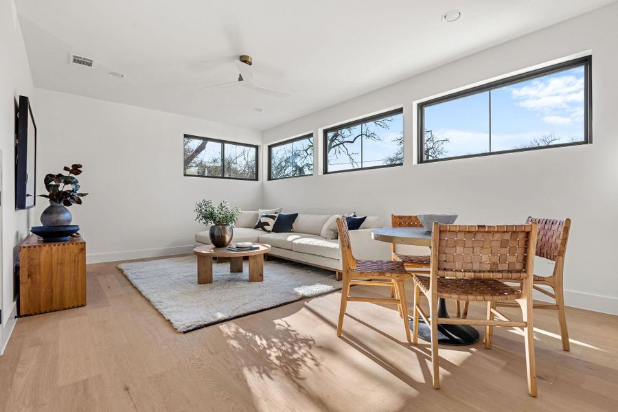Living area with ceiling fan and light wood-type flooring