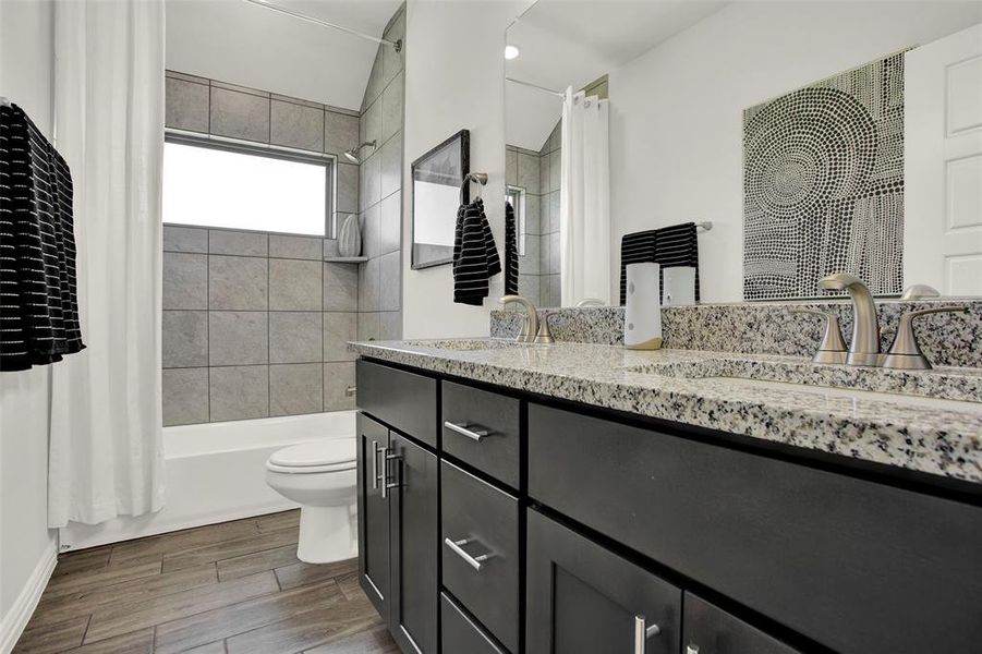 Full bathroom featuring toilet, vanity, and shower / tub combo with curtain