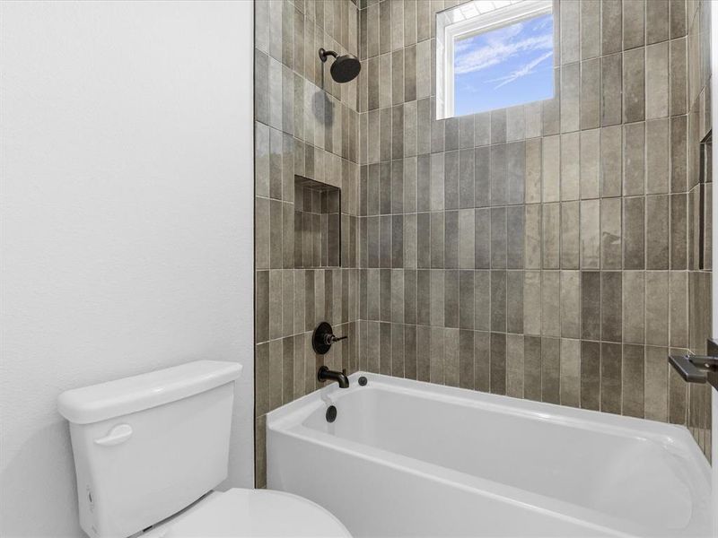 Full bathroom featuring washtub / shower combination and toilet Full bathroom featuring washtub / shower combination and toilet