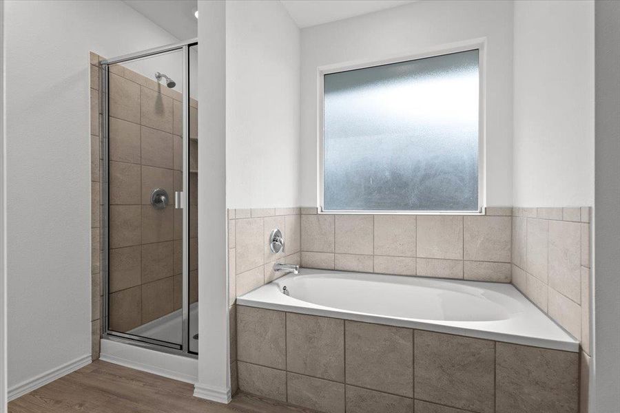 A well-appointed bathroom features a spacious corner soaking tub and a sleek glass-enclosed shower. A well-appointed bathroom features a spacious corner soaking tub and a sleek glass-enclosed shower.