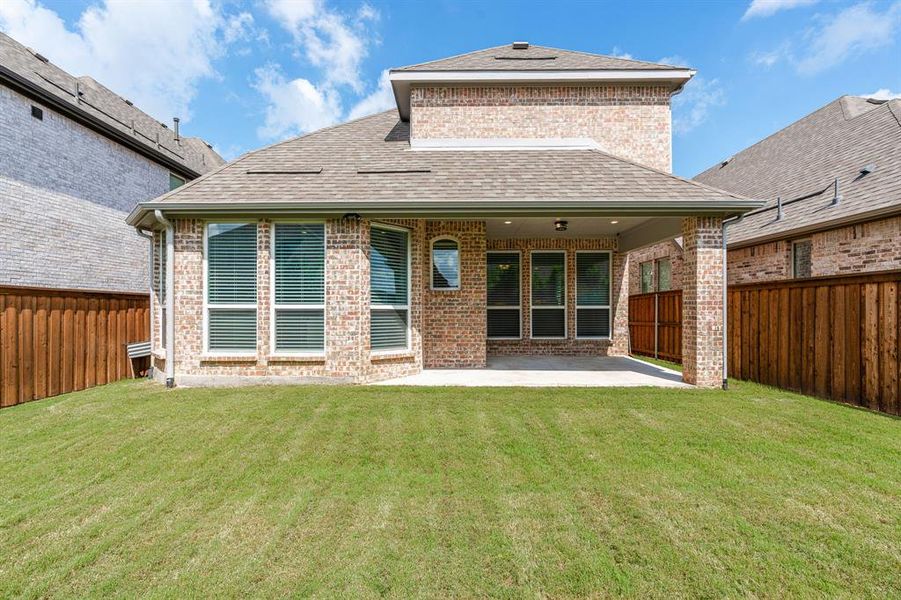 Back of house featuring a lawn and a covered patio area