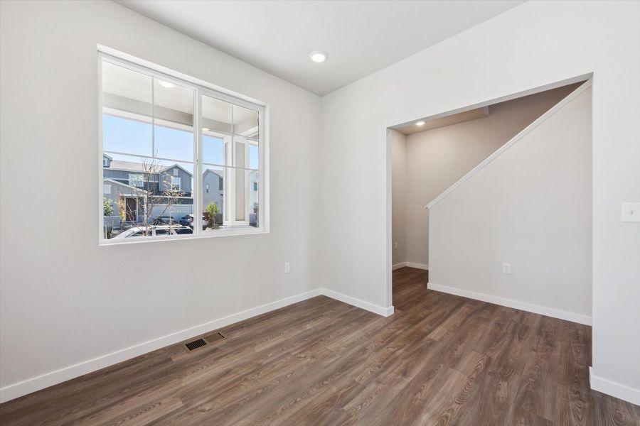 A room with a wood floor and a window with a view of the city. A room with a wood floor and a window with a view of the city.