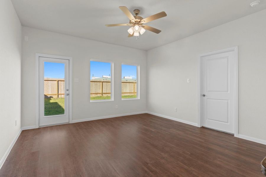 Spacious family room featuring elegant vinyl plank wood flooring and abundant natural light from large windows overlooking the backyard. The open layout makes this the perfect space for everyday living and entertaining! Spacious family room featuring elegant vinyl plank wood flooring and abundant natural light from large windows overlooking the backyard. The open layout makes this the perfect space for everyday living and entertaining!