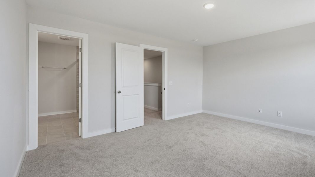 Primary bedroom with connected bathroom and walk-in shower
