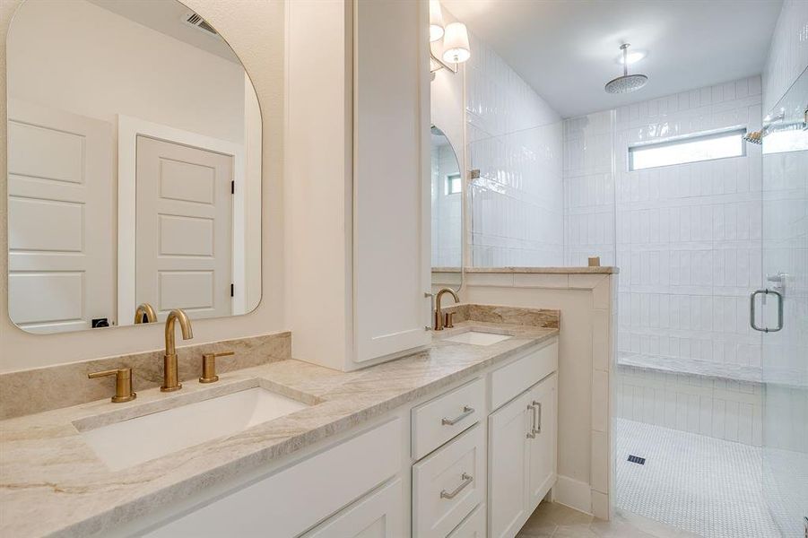 Spa-inspired bathroom with dual vanity, quartzite countertops, and Delta fixtures. Spa-inspired bathroom with dual vanity, quartzite countertops, and Delta fixtures.