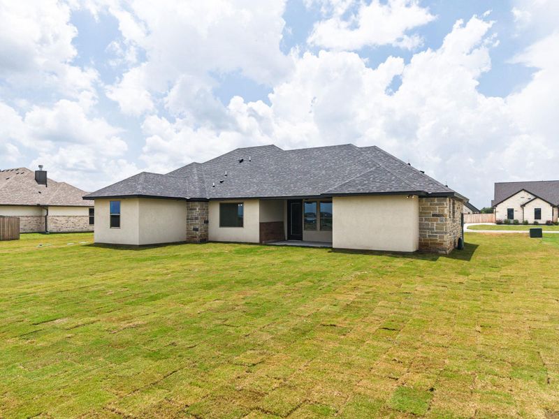 A newly built house showcasing a spacious rear facade and expansive yard, perfect for outdoor living. A newly built house showcasing a spacious rear facade and expansive yard, perfect for outdoor living.
