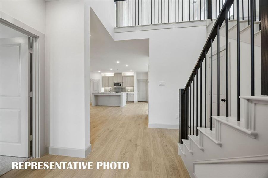 Welcome into your beautiful new dream home featuring light wood-look flooring, elegant stair railings and open sight lines throughout!  REPRESENTATIVE PHOTO