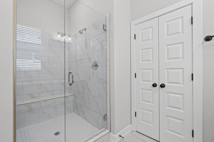 Bathroom with a shower stall, a closet, and tile patterned flooring