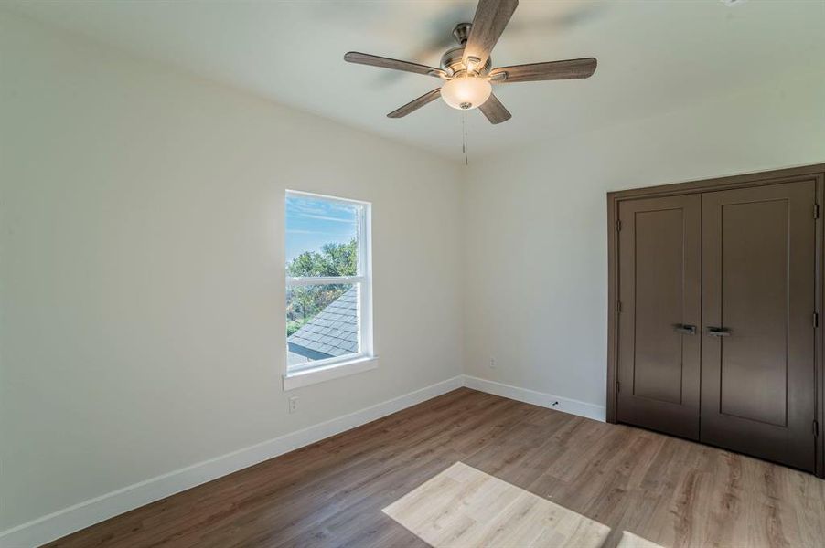 Unfurnished bedroom featuring light wood-style flooring, a closet, and ceiling fan Unfurnished bedroom featuring light wood-style flooring, a closet, and ceiling fan