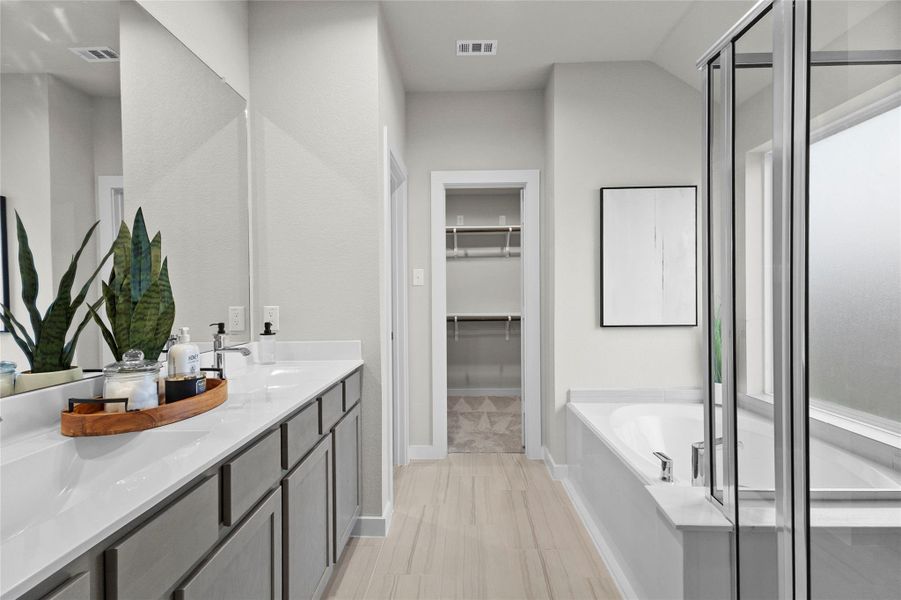 Your spacious primary bathroom features an extended dual-sink vanity, soaking tub, separate glass-enclosed shower, and direct access to the walk-in closet. Your spacious primary bathroom features an extended dual-sink vanity, soaking tub, separate glass-enclosed shower, and direct access to the walk-in closet.