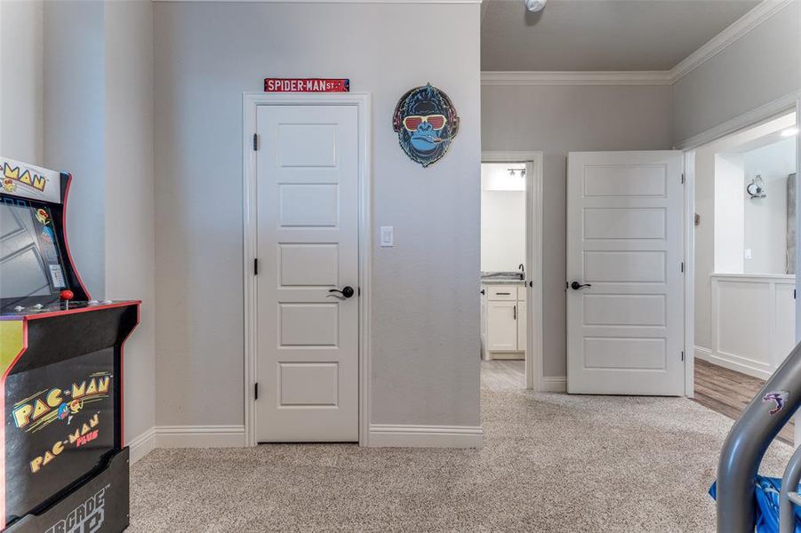 Carpeted bedroom with ornamental molding and baseboards