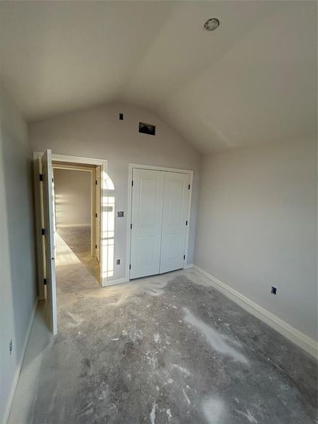 Additional living space with vaulted ceiling and unfinished concrete floors