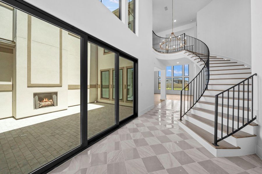 Beautiful courtyard entry showcasing the home's curved grand staircase and architectural details.