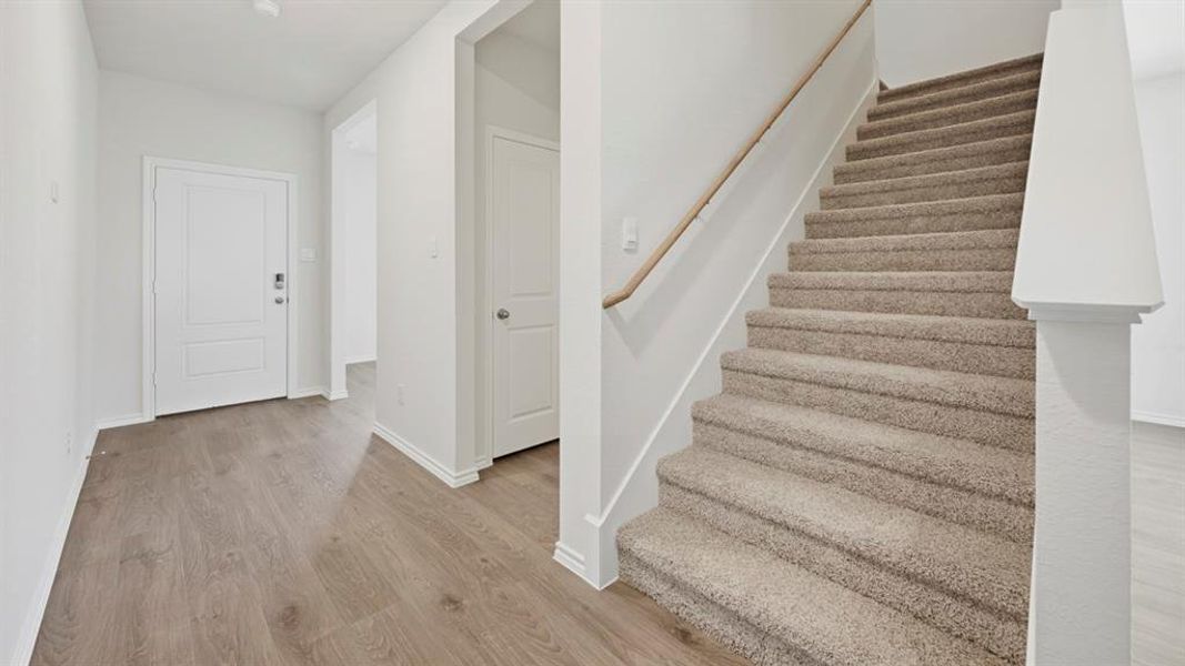 Stairway featuring wood finished floors and baseboards
