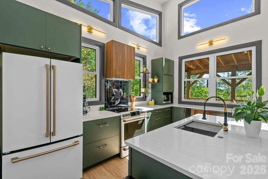Function meets form - custom cabinetry, quartz countertops, classic tambour finish on vent hood & LVP flooring.