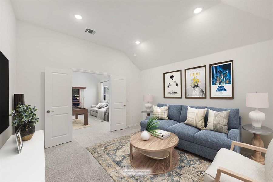 Living room with blue sofa, vaulted ceiling, framed wall art, and carpet flooring open to game room Living room with blue sofa, vaulted ceiling, framed wall art, and carpet flooring open to game room