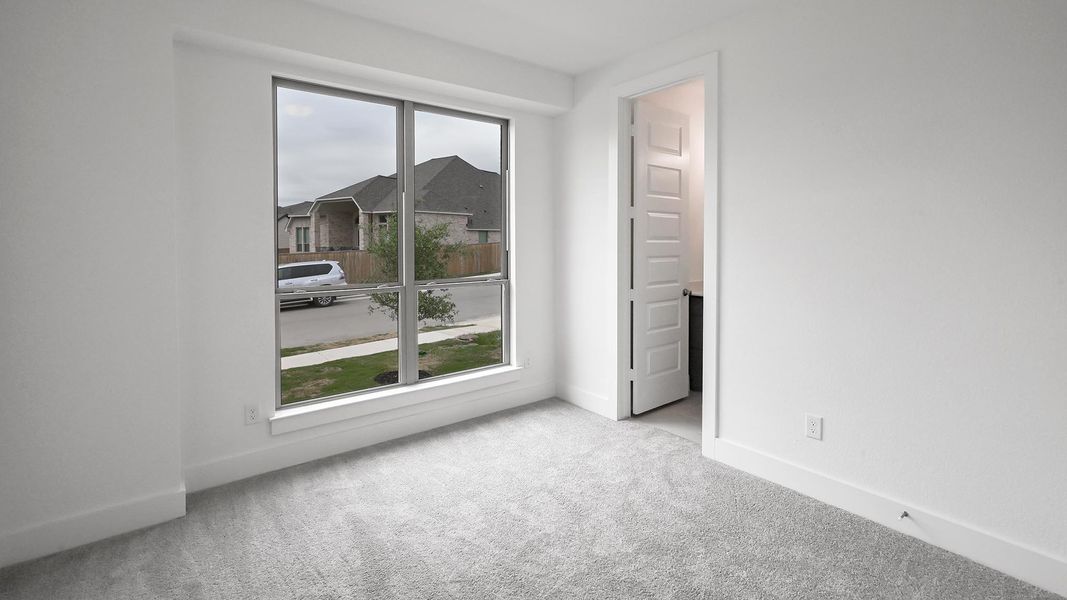 Carpeted spare room featuring baseboards and plenty of natural light