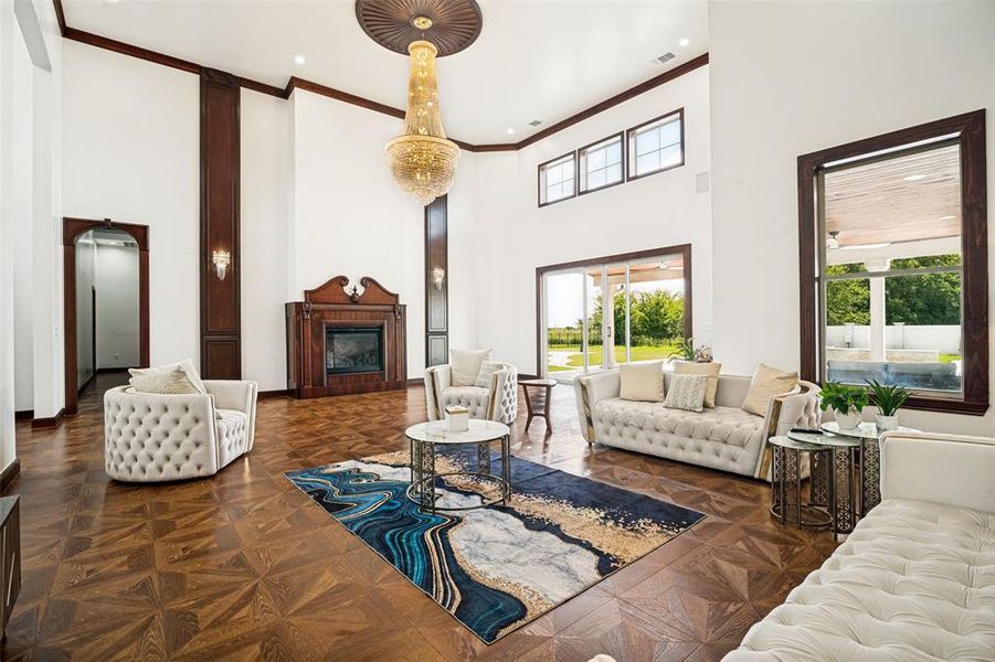 Grand living area featuring soaring ceilings, a prominent wood-finish fireplace with an ornate mantel, and intricate parquet wood-finish flooring
