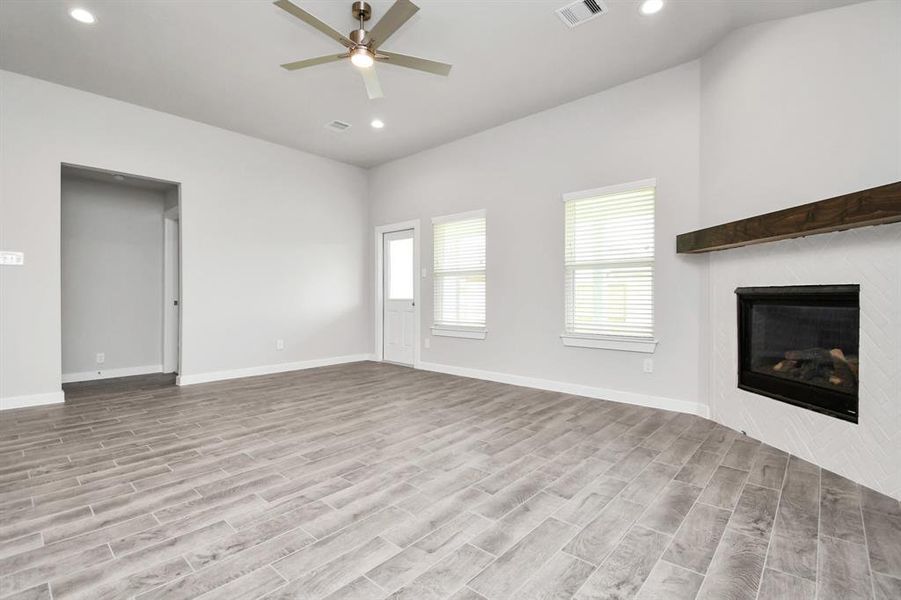 Spacious family room with large windows for natural light. Another view of the kitchen and massive island. Sample photo of completed plan. As built color and selections may vary.