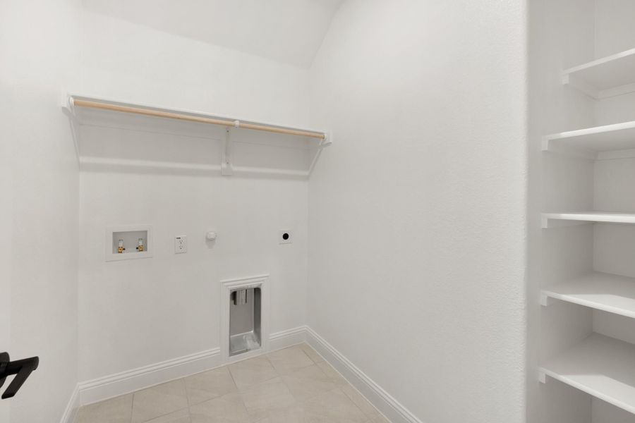 Laundry room with washer hookups, hanging rod, built-in shelves, and pet door on tile floor