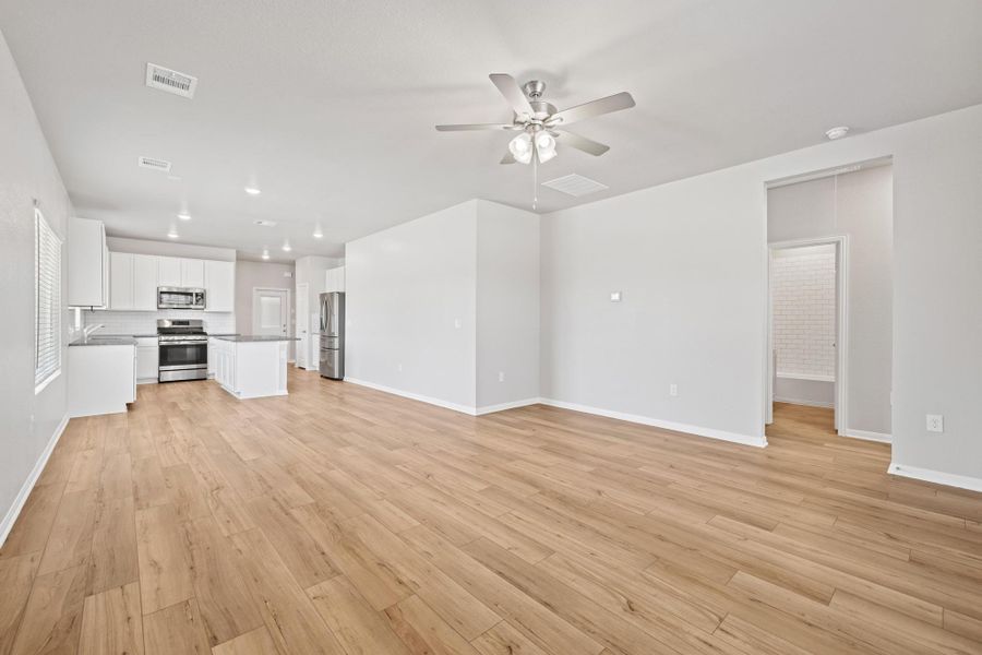 Unfurnished living room featuring light wood-style flooring, ceiling fan, and recessed lighting Unfurnished living room featuring light wood-style flooring, ceiling fan, and recessed lighting