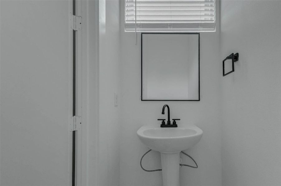 The half bath features a compact modern vanity, clean finishes, and a simple, polished look that serves the main living level conveniently.
