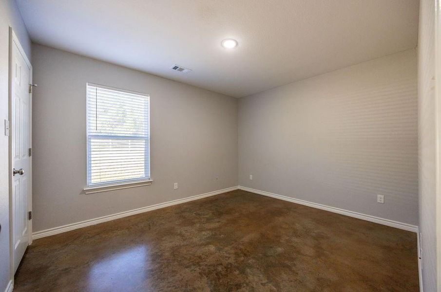 Unfurnished room with concrete flooring and baseboards