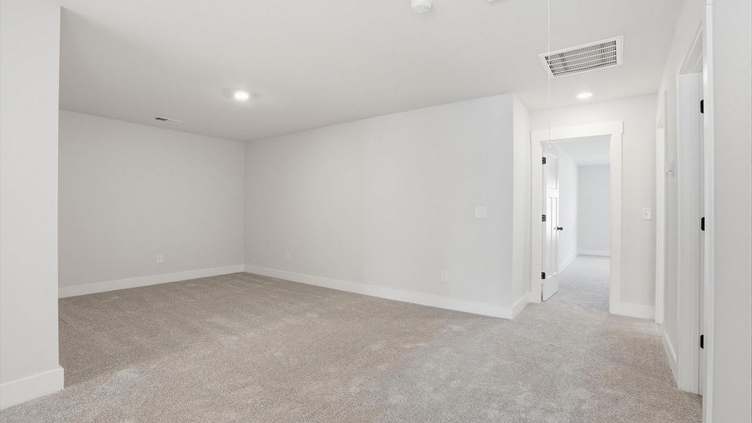 Vibrant carpeted loft offering flexibility as a study nook, game room, or second family space by DRB Homes Vibrant carpeted loft offering flexibility as a study nook, game room, or second family space by DRB Homes
