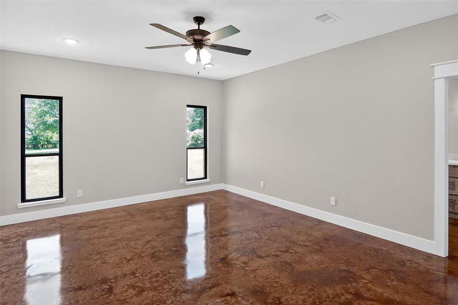 Primary Spacious room featuring polished concrete flooring, neutral wall tones, and white trim Primary Spacious room featuring polished concrete flooring, neutral wall tones, and white trim