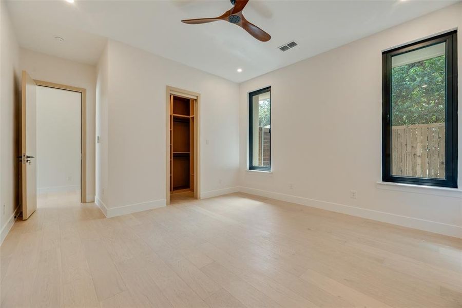 Empty room with ceiling fan and light hardwood / wood-style flooring