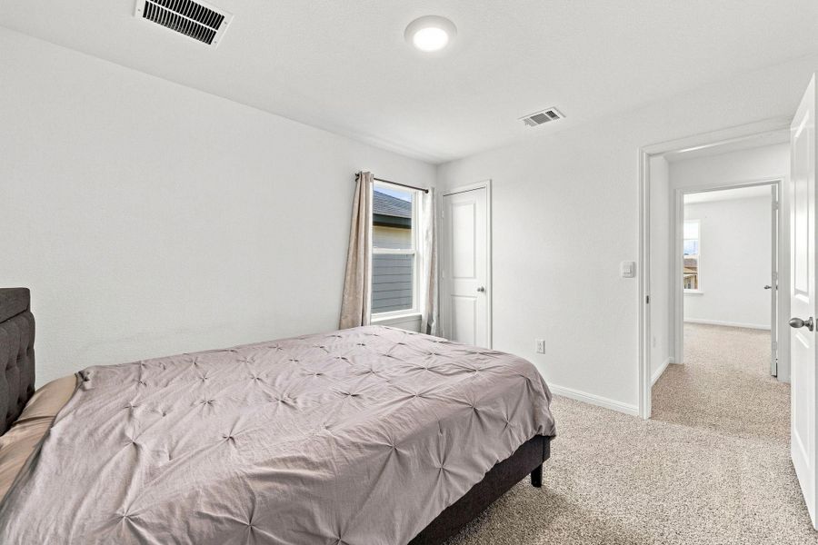 Soft carpeting pairs with crisp walls in this serene second-floor bedroom retreat.