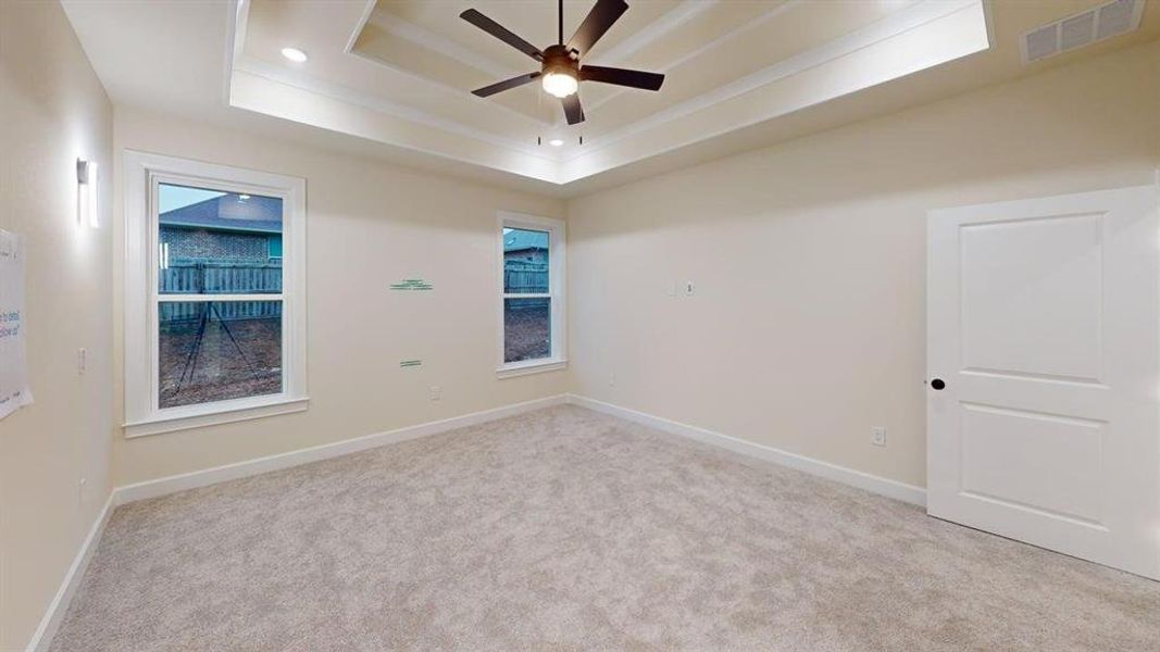 Carpeted spare room with a tray ceiling, ceiling fan, and recessed lighting