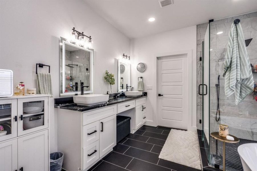 Full bath featuring double vanity, a stall shower, a freestanding tub, recessed lighting, and tile patterned floors