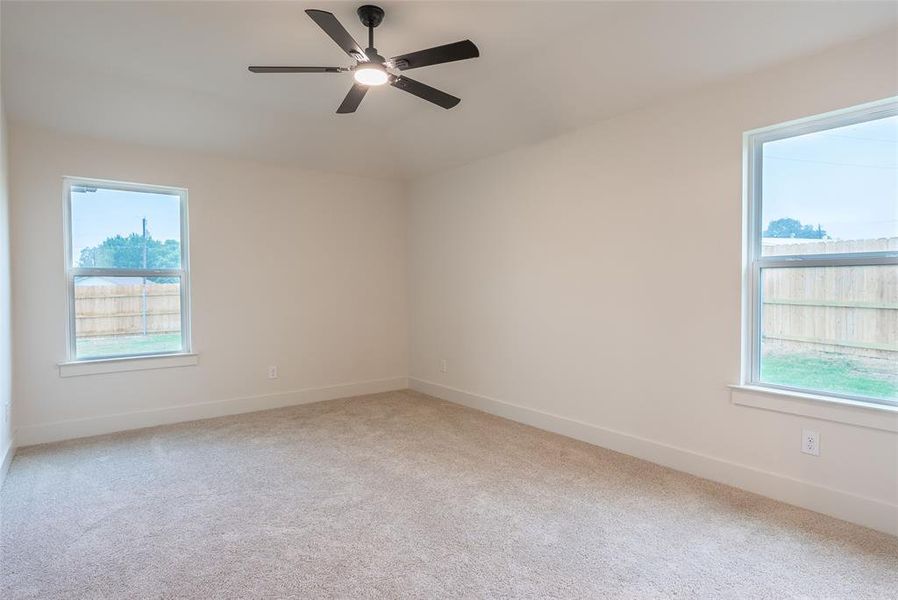 Unfurnished room featuring light carpet and ceiling fan