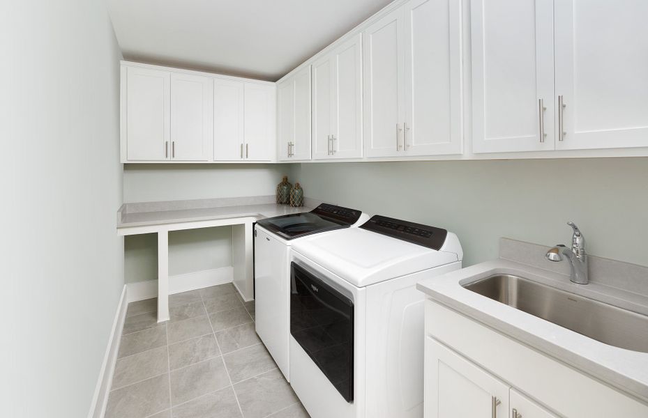 Large Laundry Room with a sink and cabinets perfect for storing cleaning supplies. Large Laundry Room with a sink and cabinets perfect for storing cleaning supplies.