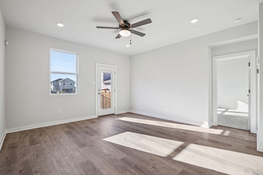 A room with a wood floor and a ceiling fan.