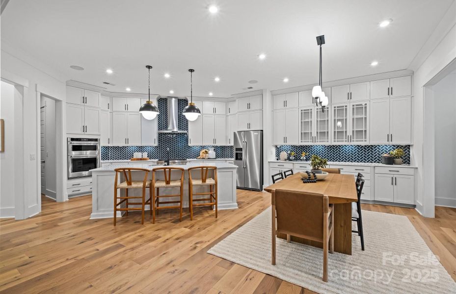 Beautifully appointed kitchen with extended cafe cabinets, quartz countertops, under cabinet lighting and luxury island