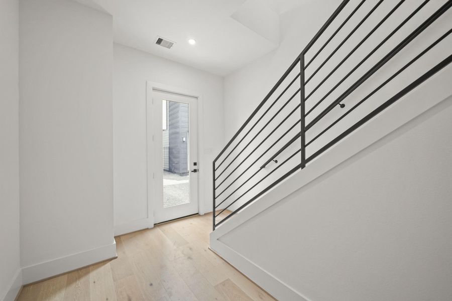 Allowing plenty of light into the entryway through the beautiful glass door, the door on the left opens to the two car garage with a Smart Qapp garage door opener and a 6’ x 4’ storage closet.