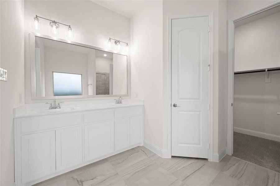 Bathroom featuring double vanity, marble finish floors, baseboards, and a shower with shower door Bathroom featuring double vanity, marble finish floors, baseboards, and a shower with shower door