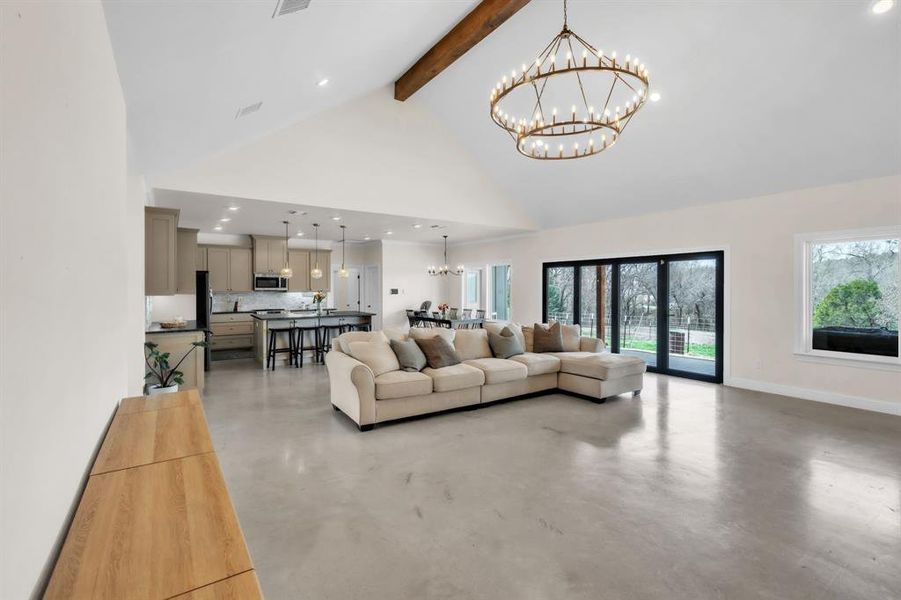 Living area with a chandelier and concrete flooring Living area with a chandelier and concrete flooring
