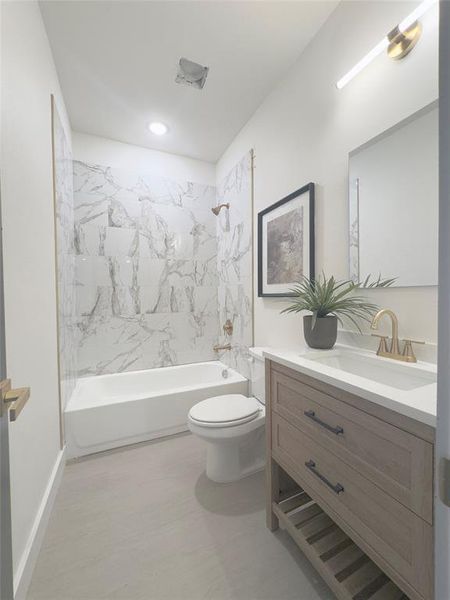 Full bathroom with tiled shower / bath, toilet, and vanity